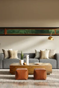 Modern living room designs featuring a low-profile cream sofa on exposed oak legs, oval oak coffee table, and large textured rug in a small apartment